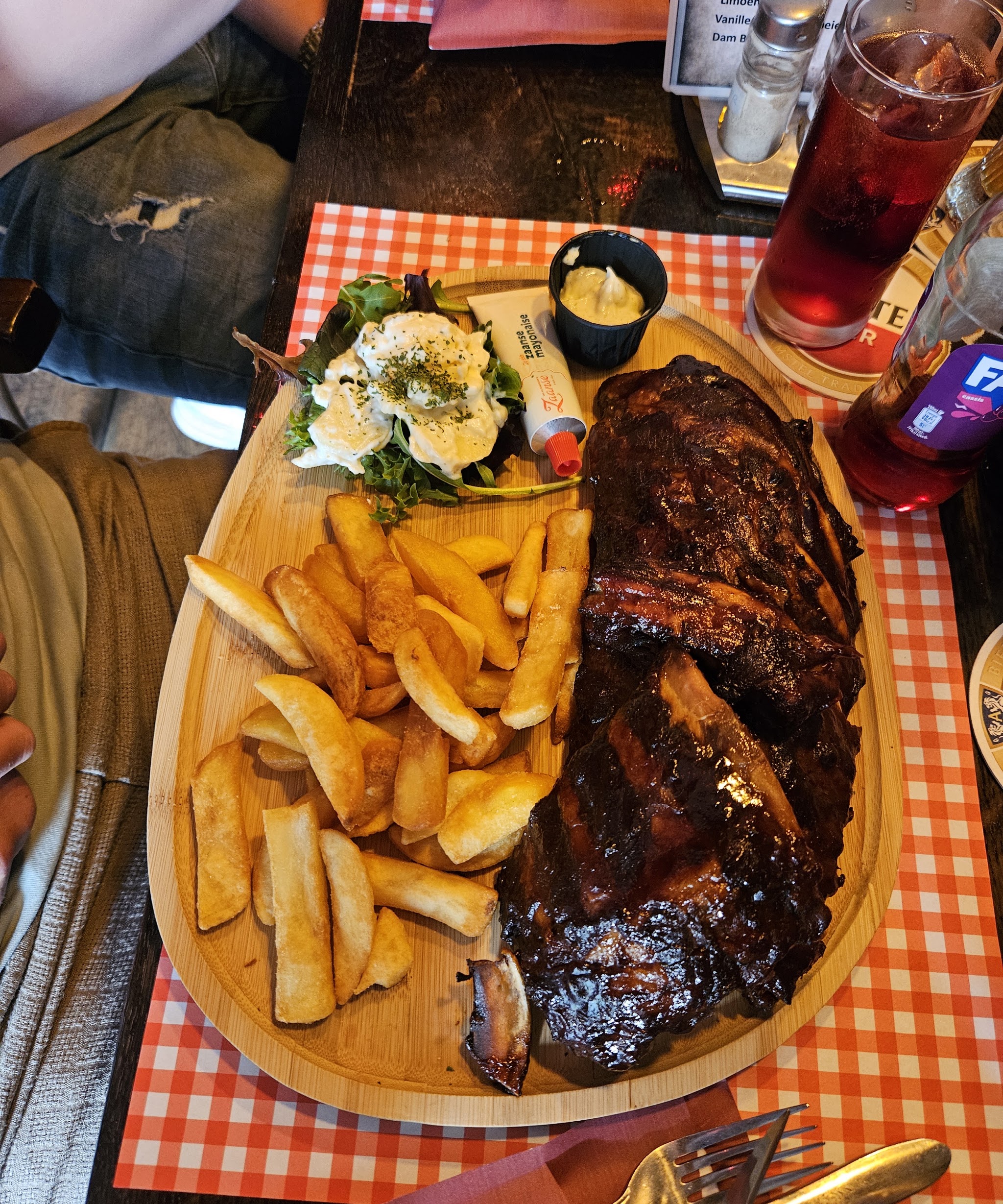 Spareribs met friet en salade op een houten plank